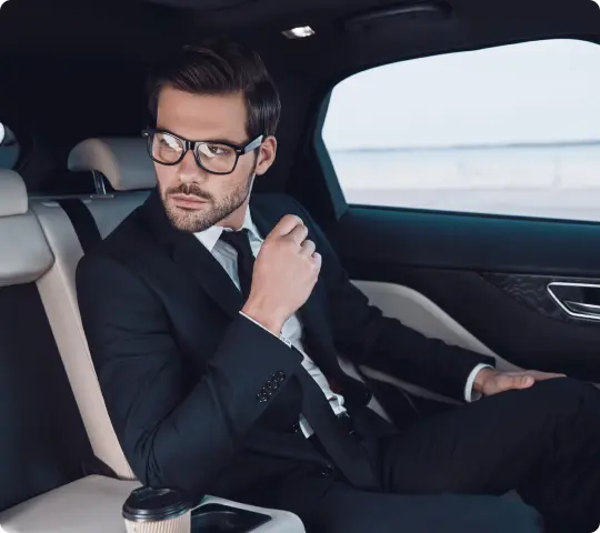 Stylish man riding in plush leather interiors, representing seamless LGA airport transfers and JFK to Manhattan rides in executive comfort.